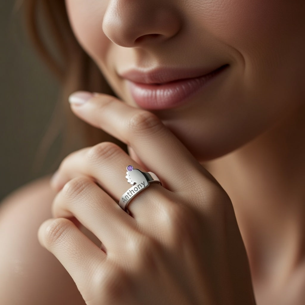 תקריב חריטת שם ואבן לידה בטבעת כף רגל תינוק